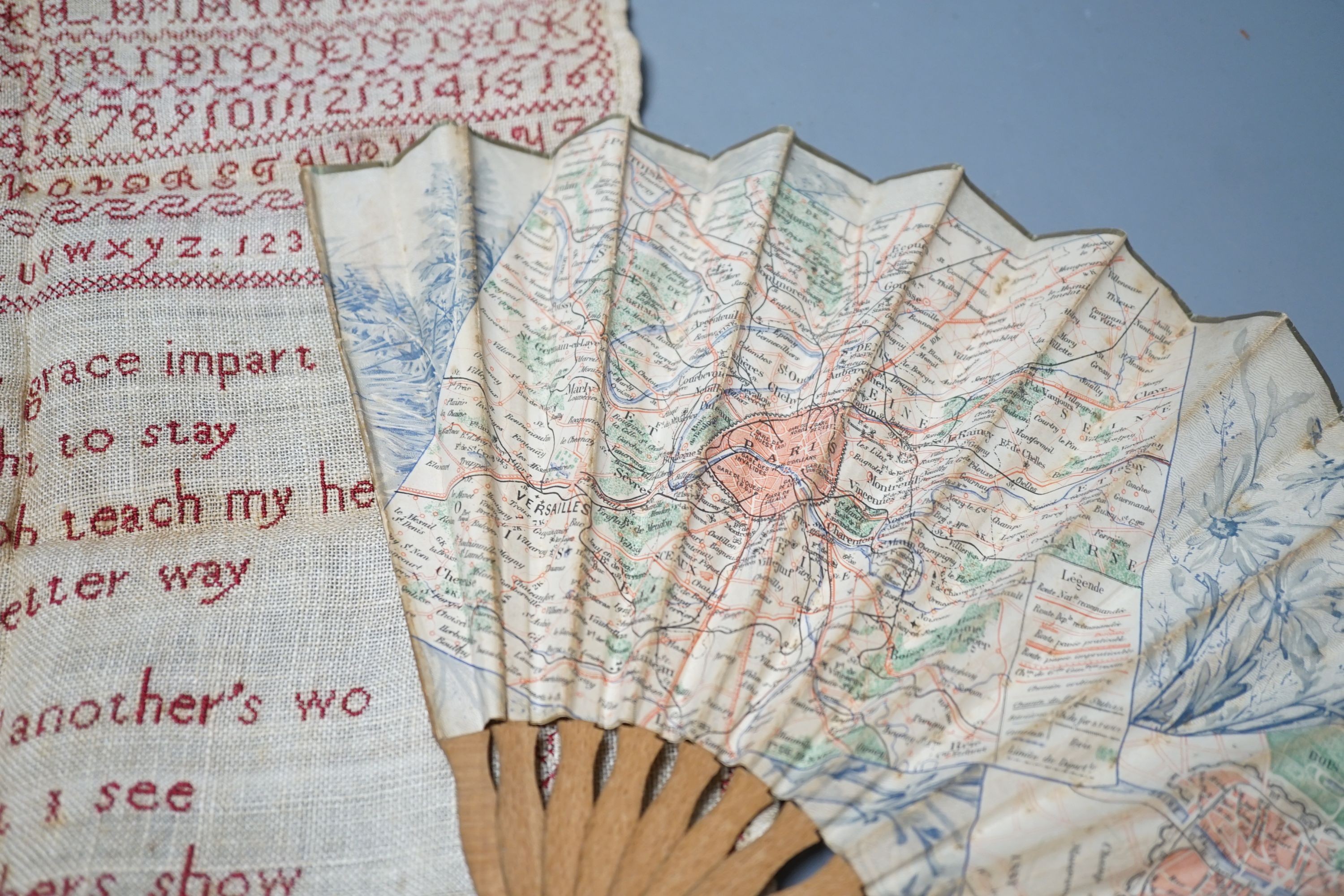 A 19th century Cycling Map of Paris fan and an 1814 cross stitch sampler